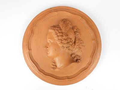 une image représentant une plaque en argile sur laquelle figure la tête d'une femme