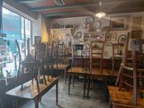 tables and chairs are lined up in a room with a large window