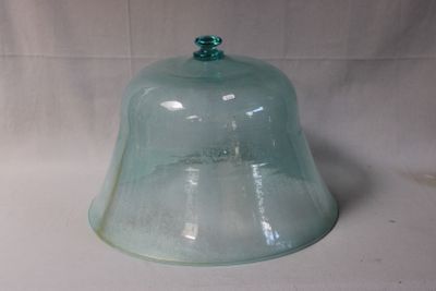 une cloche en verre avec un haut vert sur fond blanc