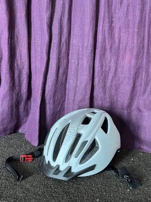 un rideau violet derrière un casque de vélo posé par terre