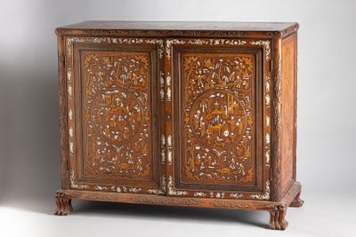 an antique carved wooden cabinet with two doors and two drawers