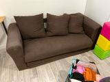 a brown couch and some colorful boxes on the floor