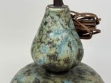 a green vase with a brown cord on top of it