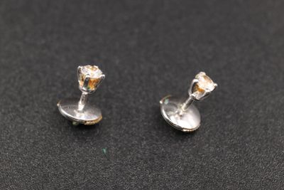 une paire de boucles d'oreilles en argent sur un fond noir