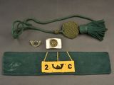a green belt with a gold medal and a green belt with a gold medal