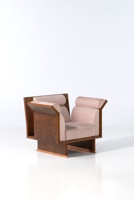 La chaise est en bois et son assise est recouverte d'un tissu beige.
