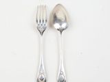 two spoons and a fork on a white surface