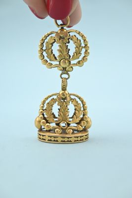 a person that is holding a small gold object
