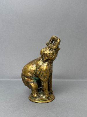 an image of a gold statue of an elephant on a gray background