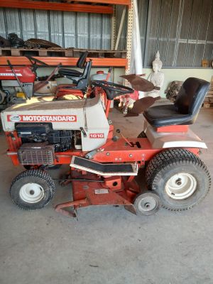 a picture of a red riding lawn mower parked in a garage