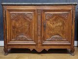 an old wooden cabinet with a marble top on a hard wood floor
