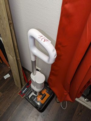 un rideau de douche rouge et blanc à côté de toilettes noires et blanches