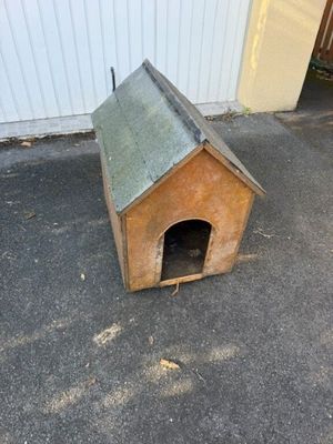 une petite niche en bois avec un toit, posée à même le sol