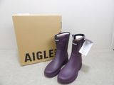 une paire de bottes de pluie violettes posées devant une boîte