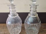 two clear glass bottles sitting on a wooden table