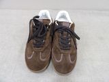 pair of brown sued sneakers with black laces on a white surface