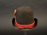 a hat on a stand with a red cord around it