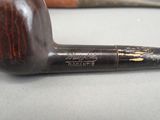a pipe that is sitting on a table next to a knife
