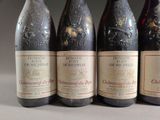four bottles of wine are lined up on a table