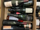 plusieurs bouteilles de vin dans un carton posé sur le sol