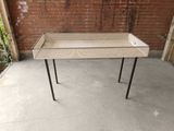 a small table with a drawer on it on a concrete floor
