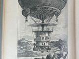 an open book with a drawing of a hot air balloon flying over a town