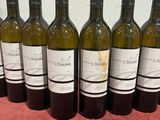 six bottles of wine are lined up on a table
