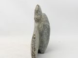 statue of a seal sitting on its back on a white surface