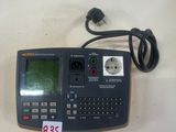 une calculatrice posée sur une table, à laquelle est relié un cordon