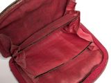 an old red suitcase with a bow on top of it