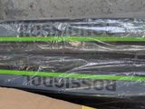 two green and black skis sitting on the ground