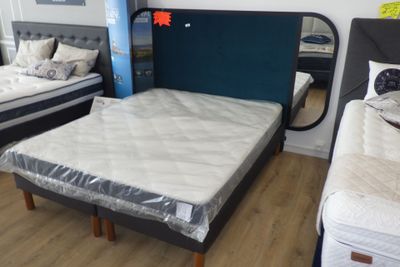 deux lits qui se trouvent dans une chambre avec une tête de lit bleue