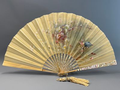 un vieux ventilateur orné d'un oiseau, posé sur une table