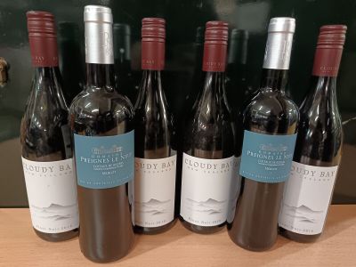 six bouteilles de vin rouge sont alignées sur une table