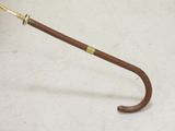a brown umbrella with a gold handle on a white floor