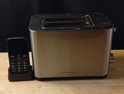 une image représentant un grille-pain et un téléphone portable posés sur une table