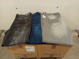 trois paires de jeans pour homme empilées sur une boîte en carton