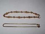 a close up of a chain and a bracelet on a table
