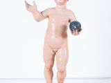 a figurine of a boy holding a ball on a wooden base