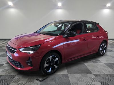 a red car is parked on a checkered floor in a showroom