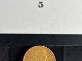 a picture of a gold coin with a picture of a woman on it