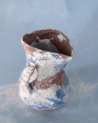 un vase bleu et blanc posé sur une surface bleue