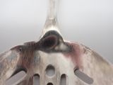 a close up of a fork with a hole in it