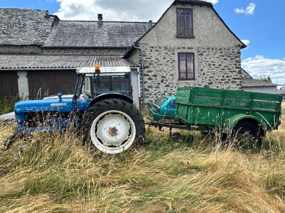 un tracteur et une remorque garés devant une maison