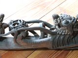 une sculpture représentant un bateau posée sur un plancher en bois