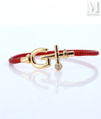 a red leather bracelet with a gold anchor on it