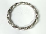 a close up of a silver bracelet on a white surface