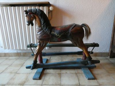 un cheval à bascule en bois posé par terre