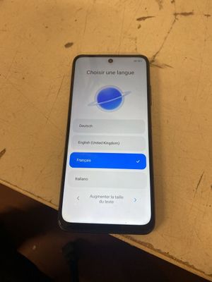 un iPhone posé sur une table en bois, à côté d'une tasse de café