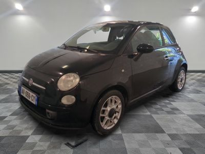 la photo d'une petite voiture noire sur un sol en damier